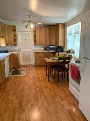 a kitchen with a wooden floor and a table at Victorian Farmhouse in The Catskills in East Meredith