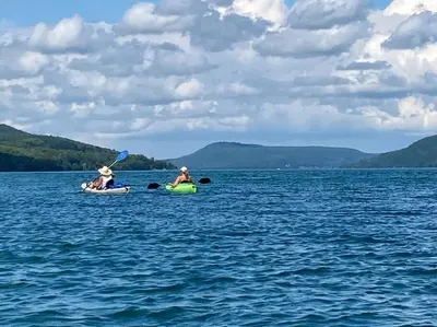 two people kayaking on the water on a lake at Victorian Farmhouse in The Catskills in East Meredith