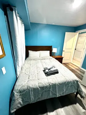 a bedroom with a bed with a blue wall at A Temporary Haven in Newark