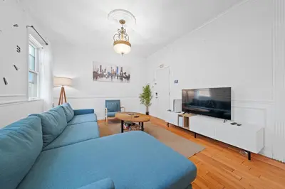 a living room with a blue couch and a tv at Stylish Apartment - Light Rail Access in Bayonne