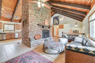 a living room with a brick fireplace and a couch at Mtn-View Home with Deck on 4 Acres in Windham in Windham