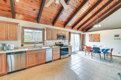 a kitchen with wooden cabinets and a table with chairs at Mtn-View Home with Deck on 4 Acres in Windham in Windham