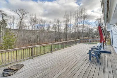 a deck with a blue bench and an umbrella at Mtn-View Home with Deck on 4 Acres in Windham in Windham