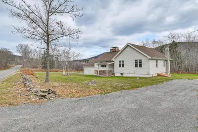 a white house sitting on the side of a road at Mtn-View Home with Deck on 4 Acres in Windham in Windham