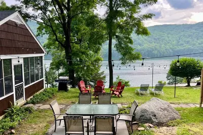 a group of chairs and a table in front of a house at Brown House, Lake, Boat Dock, King Bed, Grill in New Fairfield