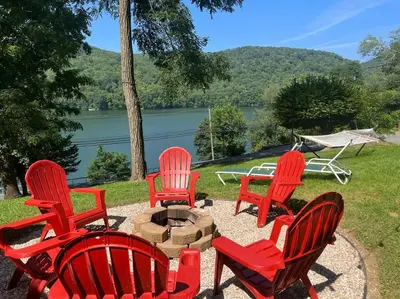 a group of red chairs sitting around a fire pit at Brown House, Lake, Boat Dock, King Bed, Grill in New Fairfield