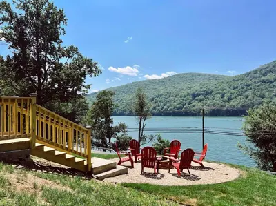 a group of chairs and a table next to a lake at Blue House, King Bed, Grill, Pool Table, Air Hockey, Ping Pong in New Fairfield