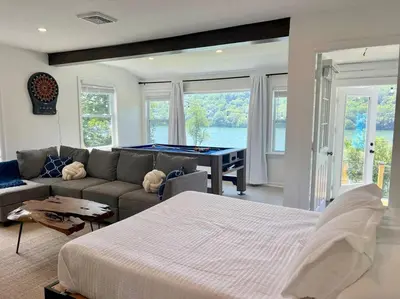 a bedroom with a bed and a couch with a pool table at Blue House, King Bed, Grill, Pool Table, Air Hockey, Ping Pong in New Fairfield