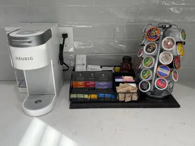 a coffee maker and books on a shelf next to a counter at Cozy Poconos Retreat Hot tub, Game room and igloo in Tobyhanna