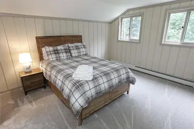 a bedroom with a bed and a lamp on a table at Private Chalet - 4 mins to Mt Snow in Dover
