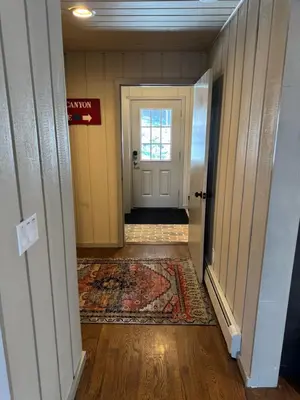 a hallway with a door and a rug at Private Chalet - 4 mins to Mt Snow in Dover