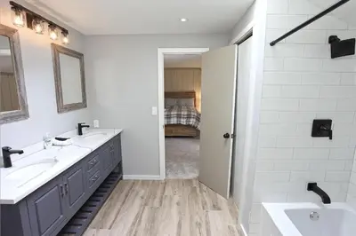 a white bathroom with two sinks and a mirror at Private Chalet - 4 mins to Mt Snow in Dover