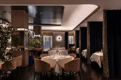 a dining room with tables and chairs and a large screen at The Knickerbocker in New York