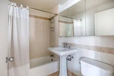 a bathroom with a sink and a tub and a toilet at Blueground UWS gym elevator nr Central Park NYC-1443 in New York