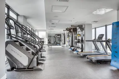 a gym with rows of treadmills and machines at Blueground LIC gym balcony nr MoMA PS1 NYC-1659 in New York