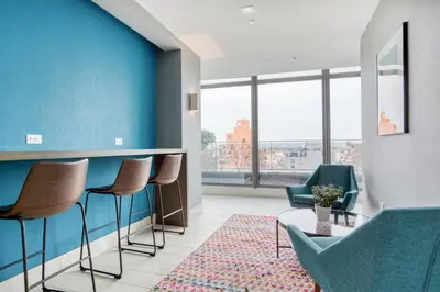 a waiting room with blue walls and chairs and a table at Blueground LIC gym balcony nr MoMA PS1 NYC-1659 in New York