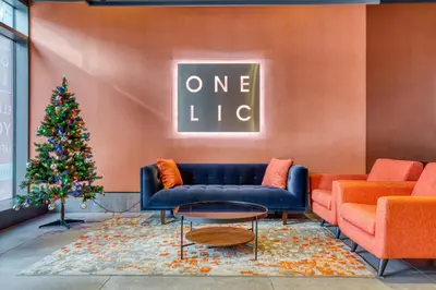a living room with a blue couch and a christmas tree at Blueground LIC gym balcony nr MoMA PS1 NYC-1659 in New York