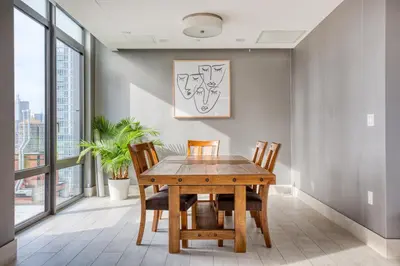 a dining room with a wooden table and chairs at Blueground LIC gym balcony nr MoMA PS1 NYC-1659 in New York