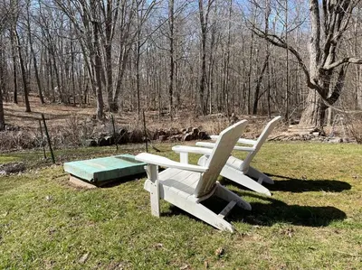 a group of white benches sitting in a field at The Hideaway in Brewster