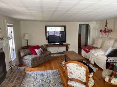 a living room with a couch and a flat screen tv at The Hideaway in Brewster