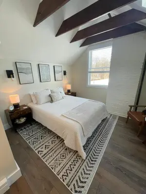 a bedroom with a large bed with a rug at The Innwoods - Studio Apartment 1 in Tannersville