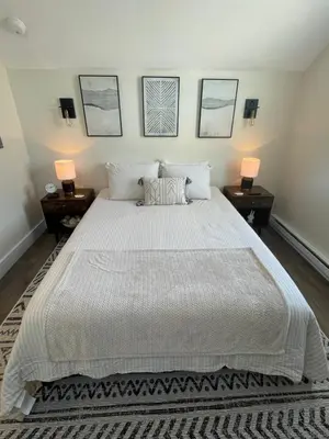a bedroom with a large white bed with two lamps at The Innwoods - Studio Apartment 1 in Tannersville