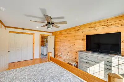 a living room with a flat screen tv on a wooden wall at Brushridge Mountain House Ski, Hike and Fish in Fleischmanns