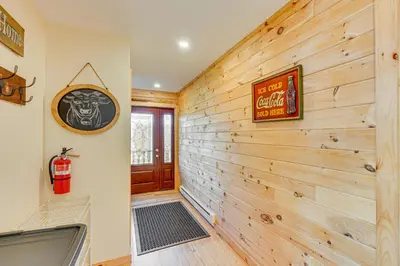 a bathroom with a wooden wall with a bath tub at Brushridge Mountain House Ski, Hike and Fish in Fleischmanns