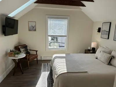 a bedroom with a bed and a window and a chair at The Innwoods - Studio Apartment 2 in Tannersville