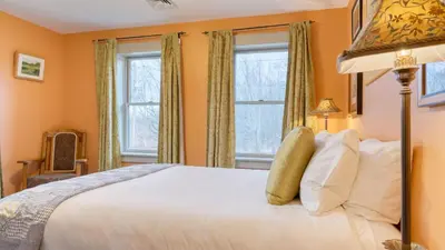 a bedroom with a white bed and two windows at Catskill Park Farm by AvantStay Huge Yard Fire Pit Near Windham Ski Resort in Prattsville