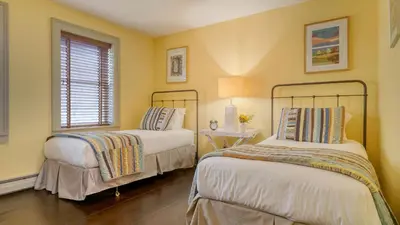 two beds in a room with yellow walls at Catskill Park Farm by AvantStay Huge Yard Fire Pit Near Windham Ski Resort in Prattsville
