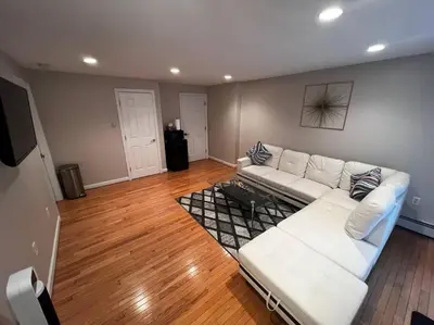 a living room with a white couch and wooden floors at Premium Private Suite with Parking and Workspace in South Windsor