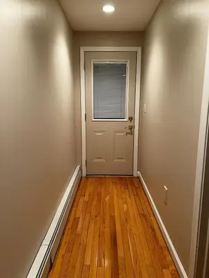 an empty hallway with a door and wooden floors at Premium Private Suite with Parking and Workspace in South Windsor
