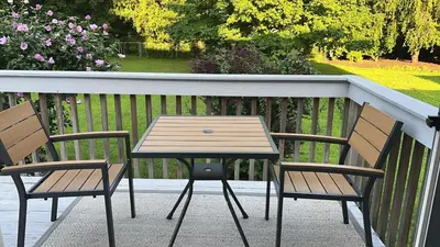 a wooden table and two chairs on a porch at Premium Private Suite with Parking and Workspace in South Windsor
