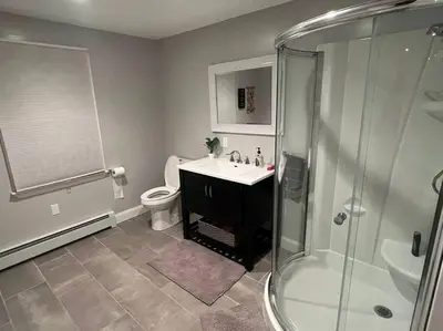 a bathroom with a shower and a sink and a toilet at Premium Private Suite with Parking and Workspace in South Windsor
