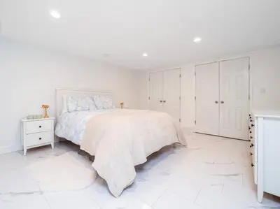 a white bedroom with a bed and white cabinets at New Canaan's Downtown Retreat in New Canaan