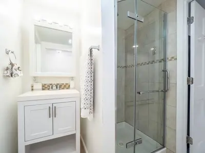 a bathroom with a sink and a glass shower at New Canaan's Downtown Retreat in New Canaan
