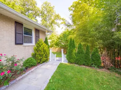 a house with a sidewalk next to a yard at New Canaan's Downtown Retreat in New Canaan