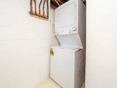 a laundry room with a washer and dryer next to a wall at New Canaan's Downtown Retreat in New Canaan