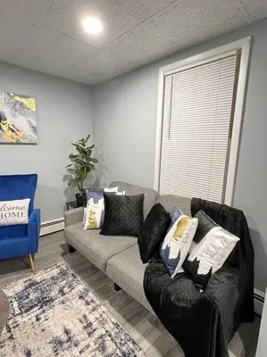 a living room with a couch and a window at Criscaris Homes in New Britain