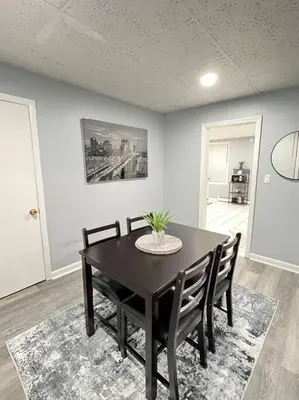 a dining room with a black table and chairs at Criscaris Homes in New Britain