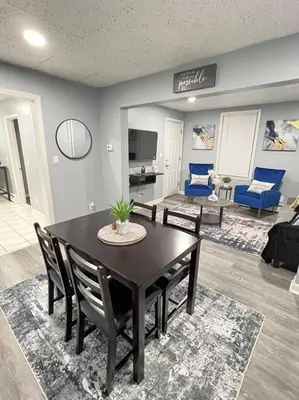 a dining room with a table and chairs and a living room at Criscaris Homes in New Britain