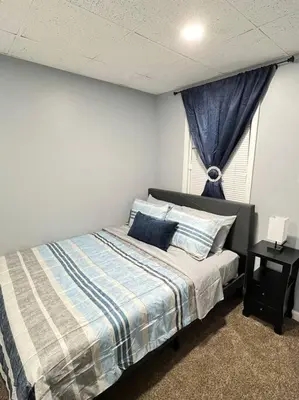 a bedroom with a bed and a window at Criscaris Homes in New Britain