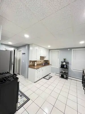 a kitchen with white cabinets and a black stove at Criscaris Homes in New Britain