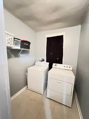 a laundry room with two machines and a window at Criscaris Homes in New Britain