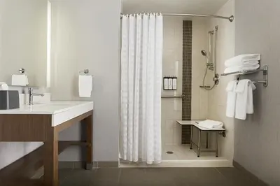a bathroom with a shower curtain and a sink at Hyatt Place New York Yonkers in Yonkers