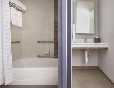a bathroom with a white tub and a sink at Hyatt Place New York Yonkers in Yonkers