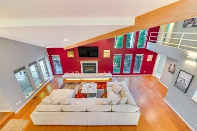 a living room with a white couch and a red wall at 7 Mi to Skiing Lake George Home with Large Patio in Queensbury