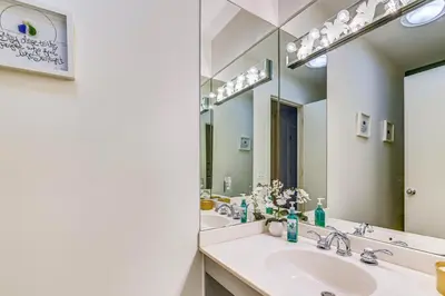 a bathroom with two sinks and a large mirror at 7 Mi to Skiing Lake George Home with Large Patio in Queensbury
