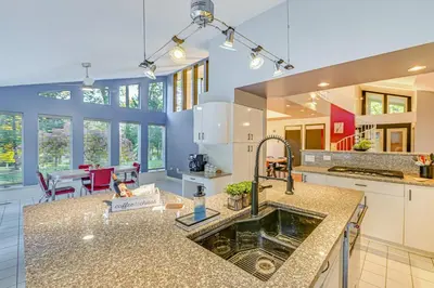 a kitchen with a sink and a dining room at 7 Mi to Skiing Lake George Home with Large Patio in Queensbury